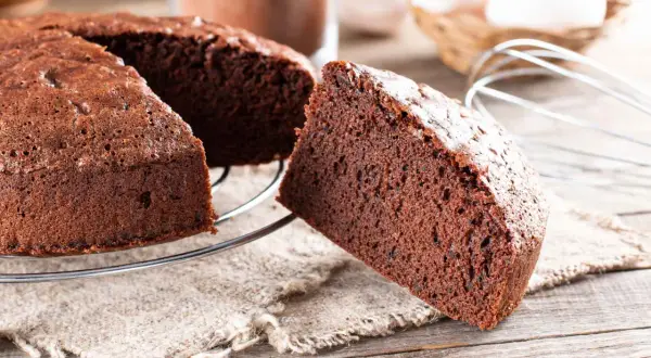 Una fetta di torta alla Nutella soffice e golosa, appena sfornata, su una griglia di raffreddamento.