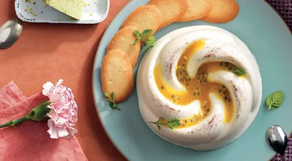 Deliziosa crema al latte con frutto della passione e biscotti croccanti, guarnita con menta fresca.
