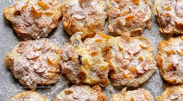 Biscotti croccanti, simili a rose del deserto, ricoperti di zucchero a velo e fiocchi di mais.