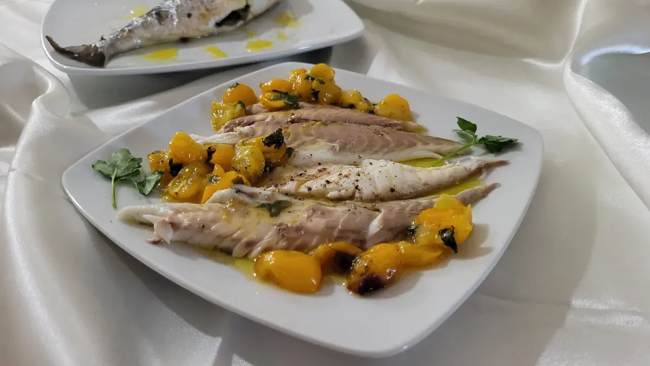 Orata in friggitrice ad aria, servita con pomodorini gialli e prezzemolo. Un piatto leggero e gustoso.