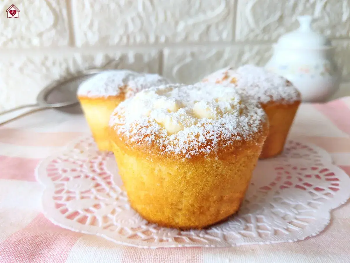 Muffin dorati spolverati di zucchero a velo, perfetti per una ricetta muffin semplici e golosa.