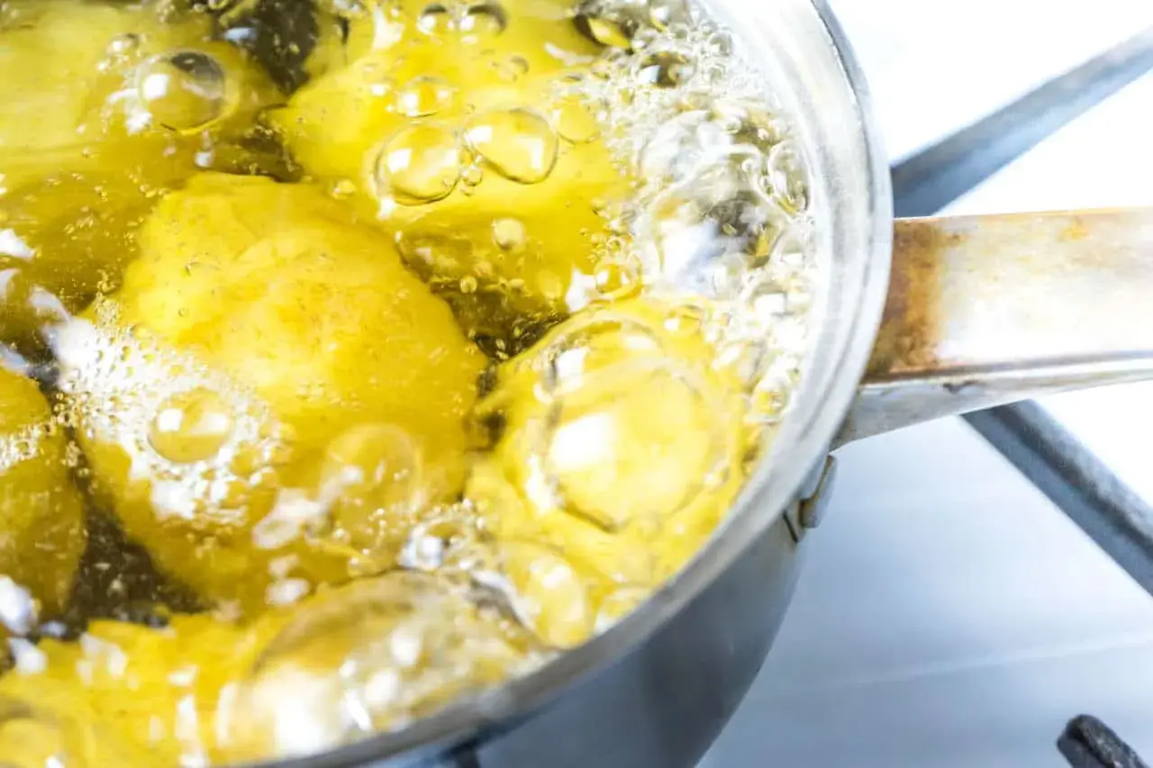 Patate senza buccia che bollono in una pentola. Il tempo di cottura patate lesse senza buccia è quasi terminato, le bollicine indicano che sono pronte.