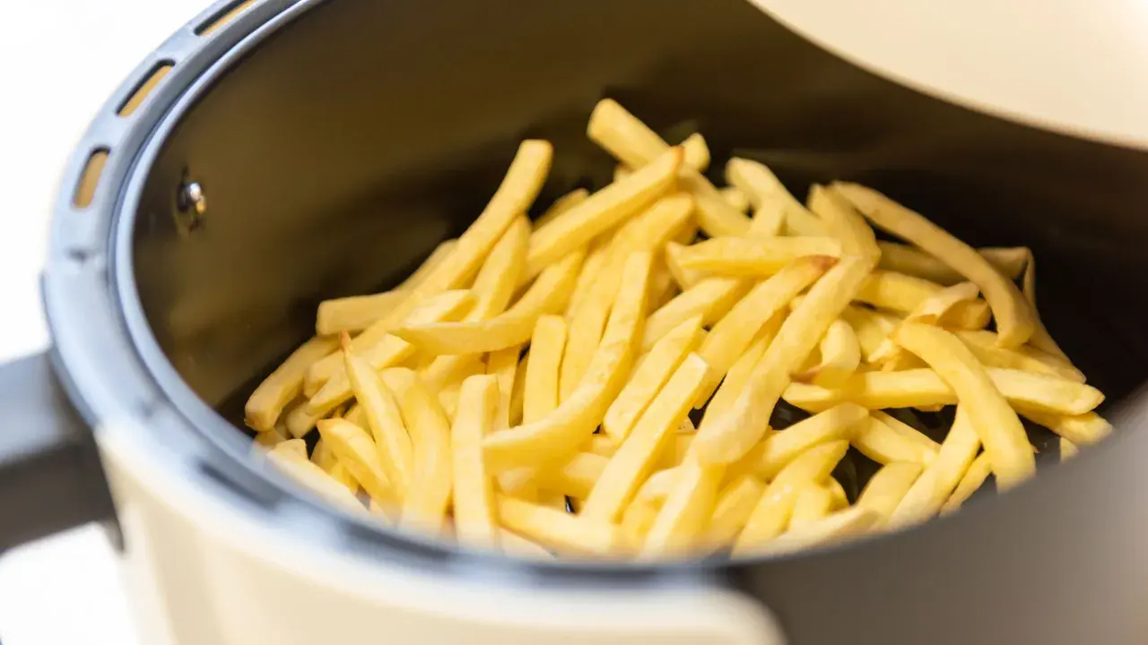 Patate dorate e croccanti pronte per essere gustate, appena uscite dalla friggitrice ad aria.
