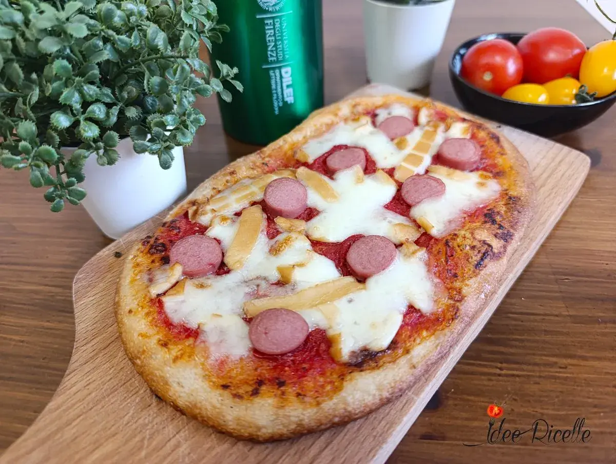 Deliziose pizzette fatte in casa con wurstel e formaggio filante, pronte per essere gustate.