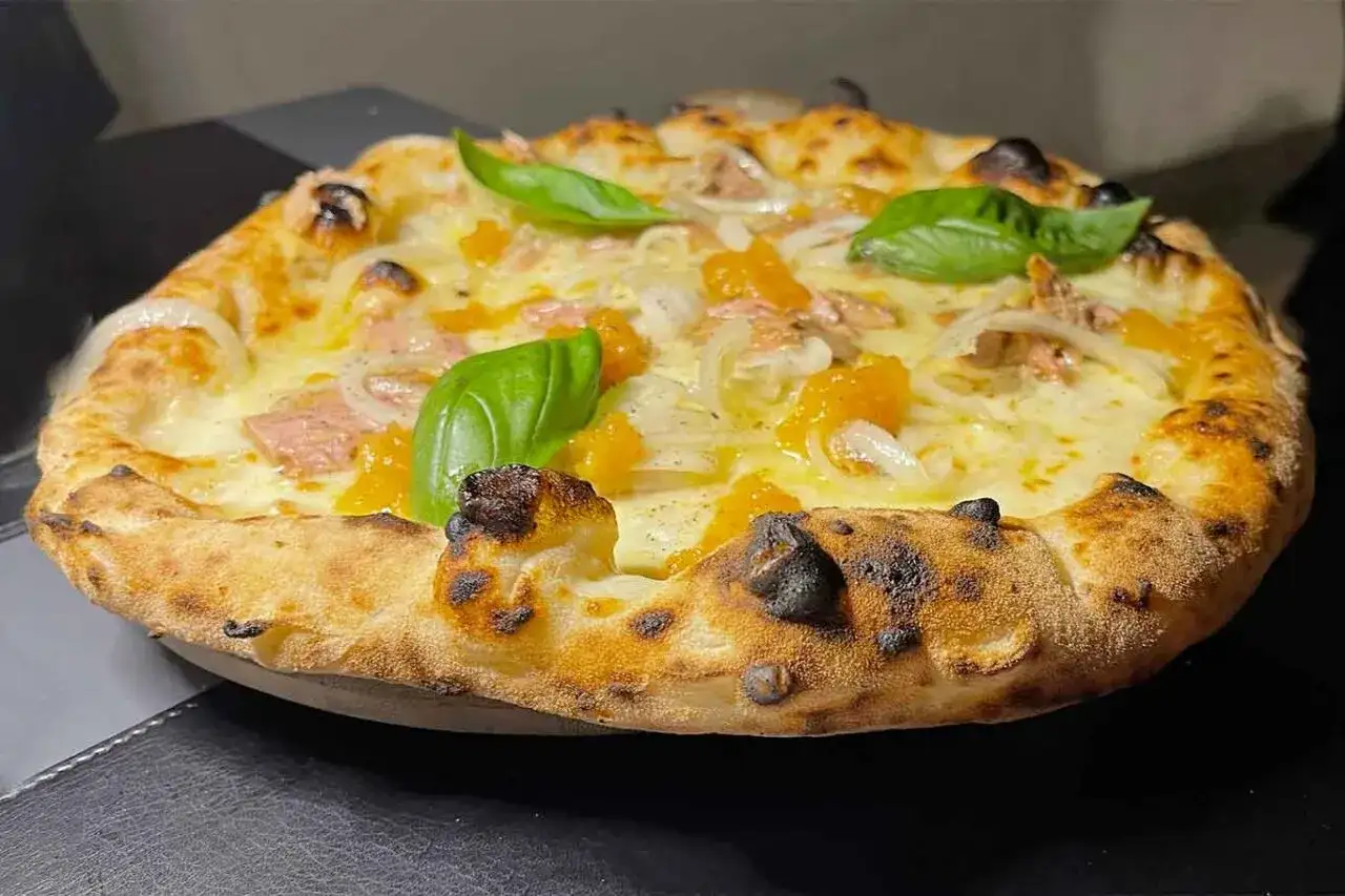 Pizza tonno e cipolla con mozzarella filante, pomodorini e basilico fresco. Croccante e saporita, un classico intramontabile.