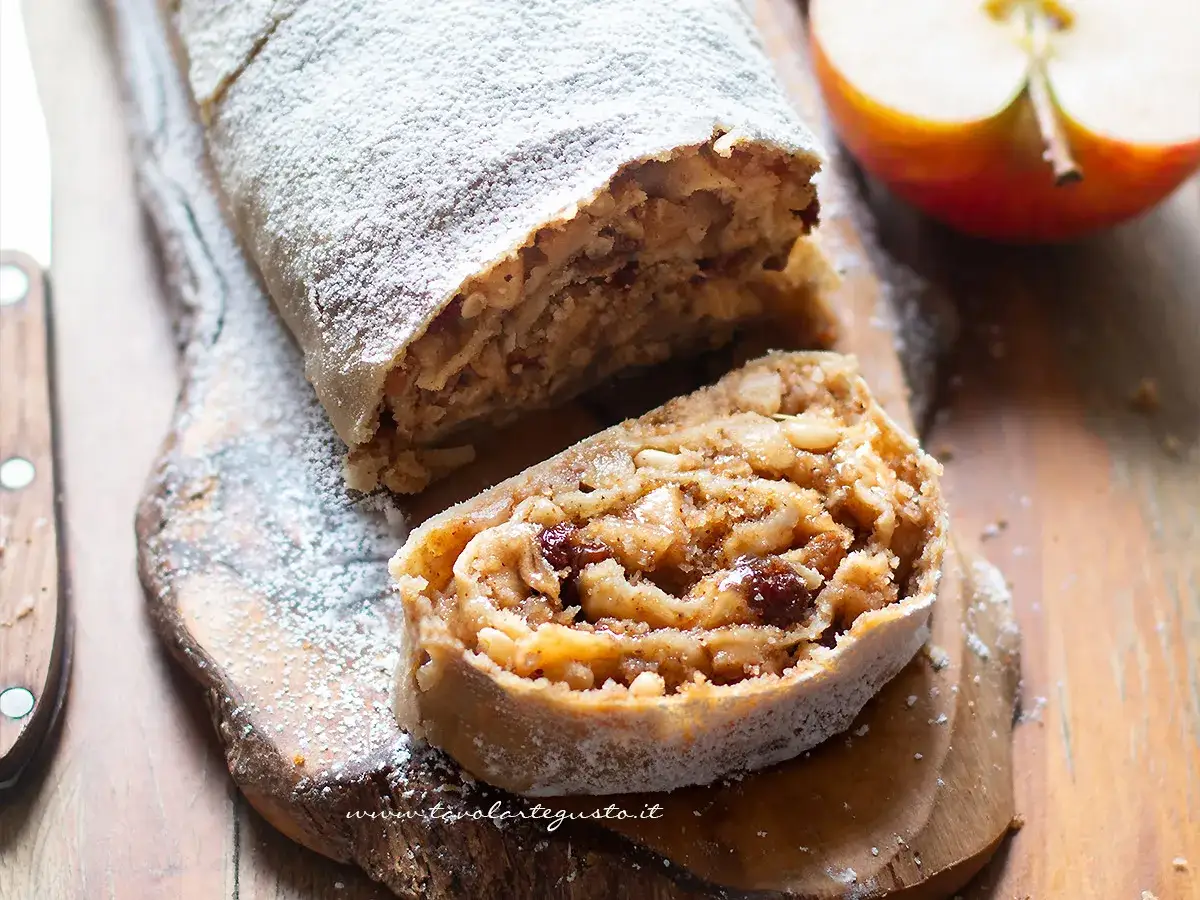 Delizioso strudel di mele, cosparso di zucchero a velo, pronto per essere gustato. Una ricetta strudel di mele perfetta per ogni occasione.