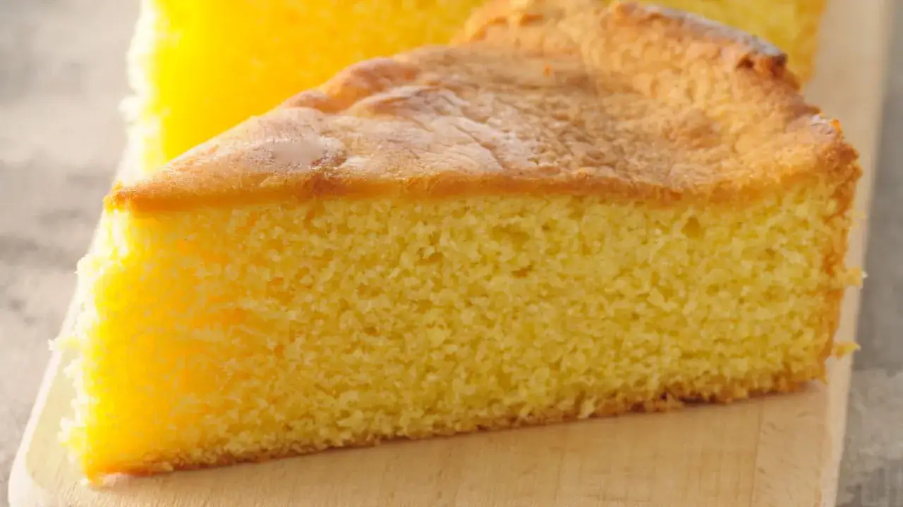 Una fetta soffice e dorata di torta 7 vasetti, con la sua consistenza ariosa e il profumo invitante, pronta per essere gustata.