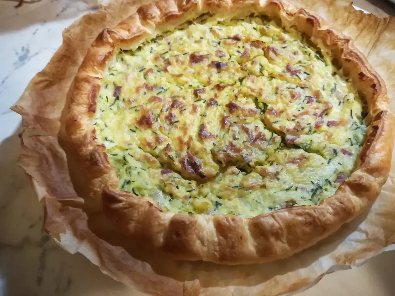 Torta salata con pasta sfoglia e zucchine, dorata e invitante, pronta per essere gustata.