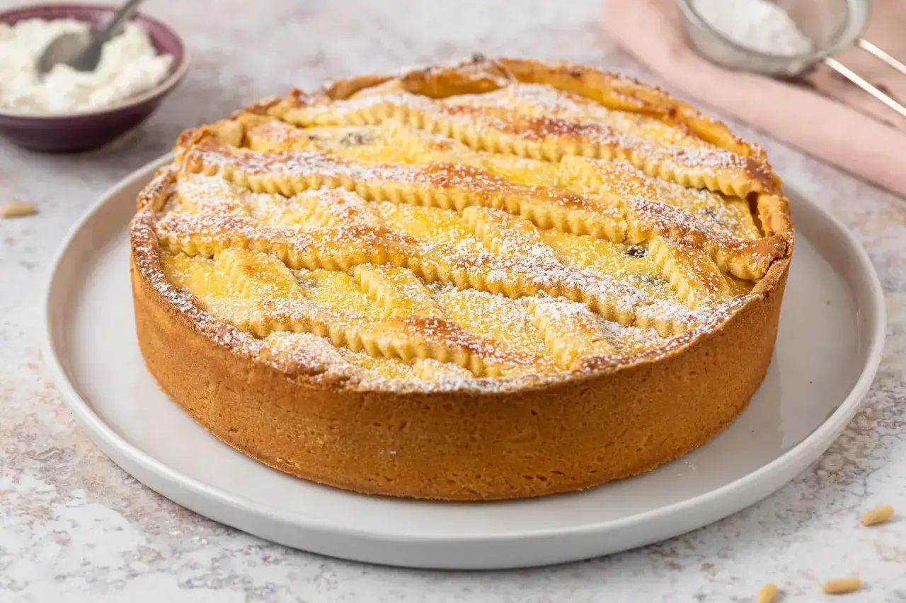 Deliziosa crostata di ricotta con decorazione a griglia, spolverata di zucchero a velo. Perfetta per ogni occasione.