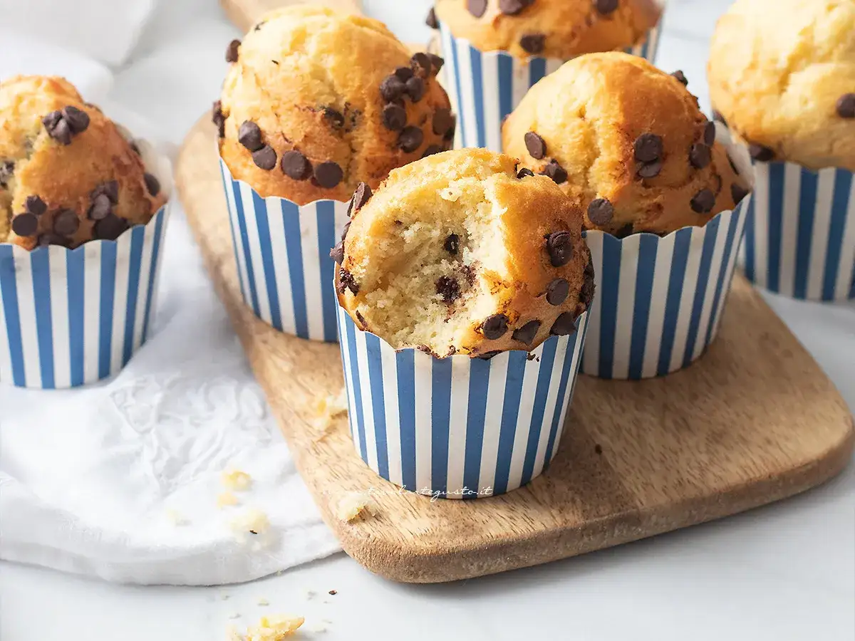 Muffin alla friggitrice ad aria con gocce di cioccolato, uno è stato morso mostrando l'interno soffice.
