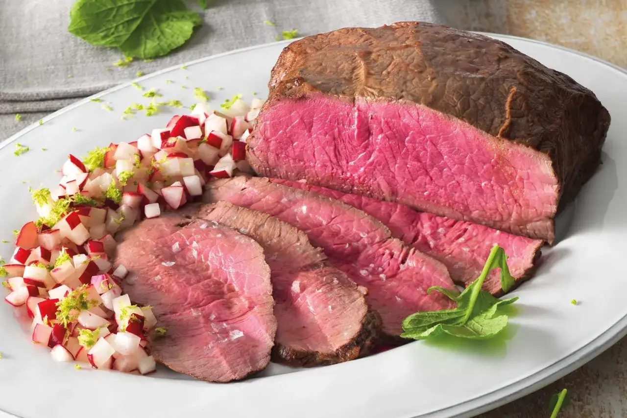 Roast beef ricetta classica: succulento e rosato, servito con un contorno fresco di ravanelli e scorza di lime.