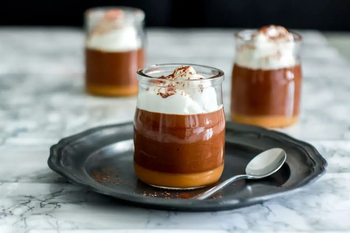 Delizioso latte alla portoghese in bicchierini, con panna montata e cacao.