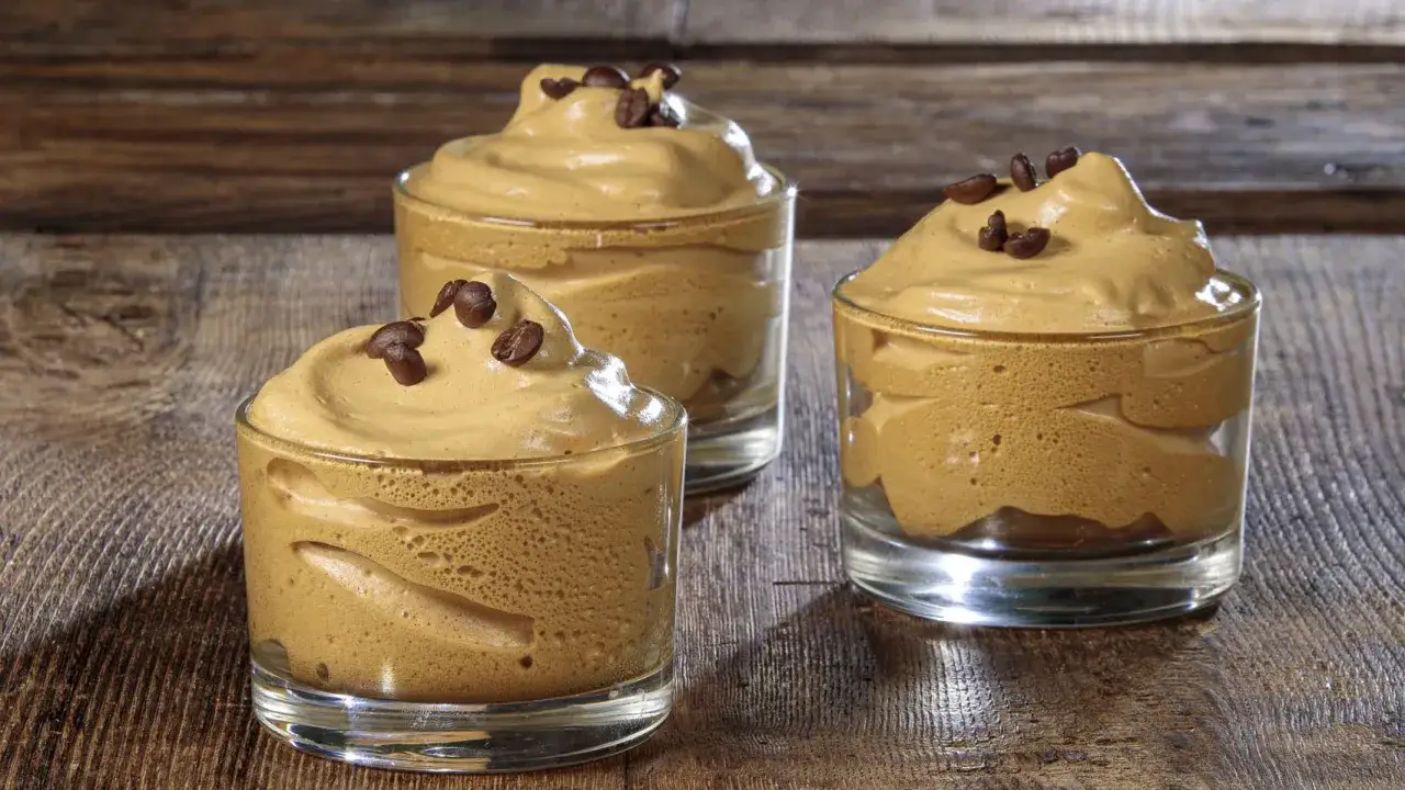 Tre bicchierini di soffice crema di caff&egrave; senza panna, guarniti con chicchi di caff&egrave;, perfetti per una ricetta veloce e golosa.