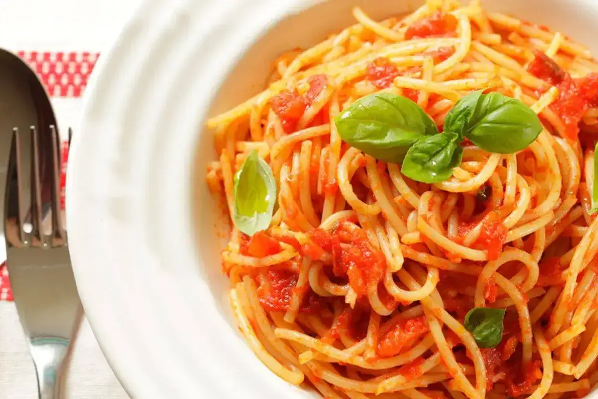 Un piatto invitante di spaghetti con pomodorini freschi e basilico, pronto per essere gustato.