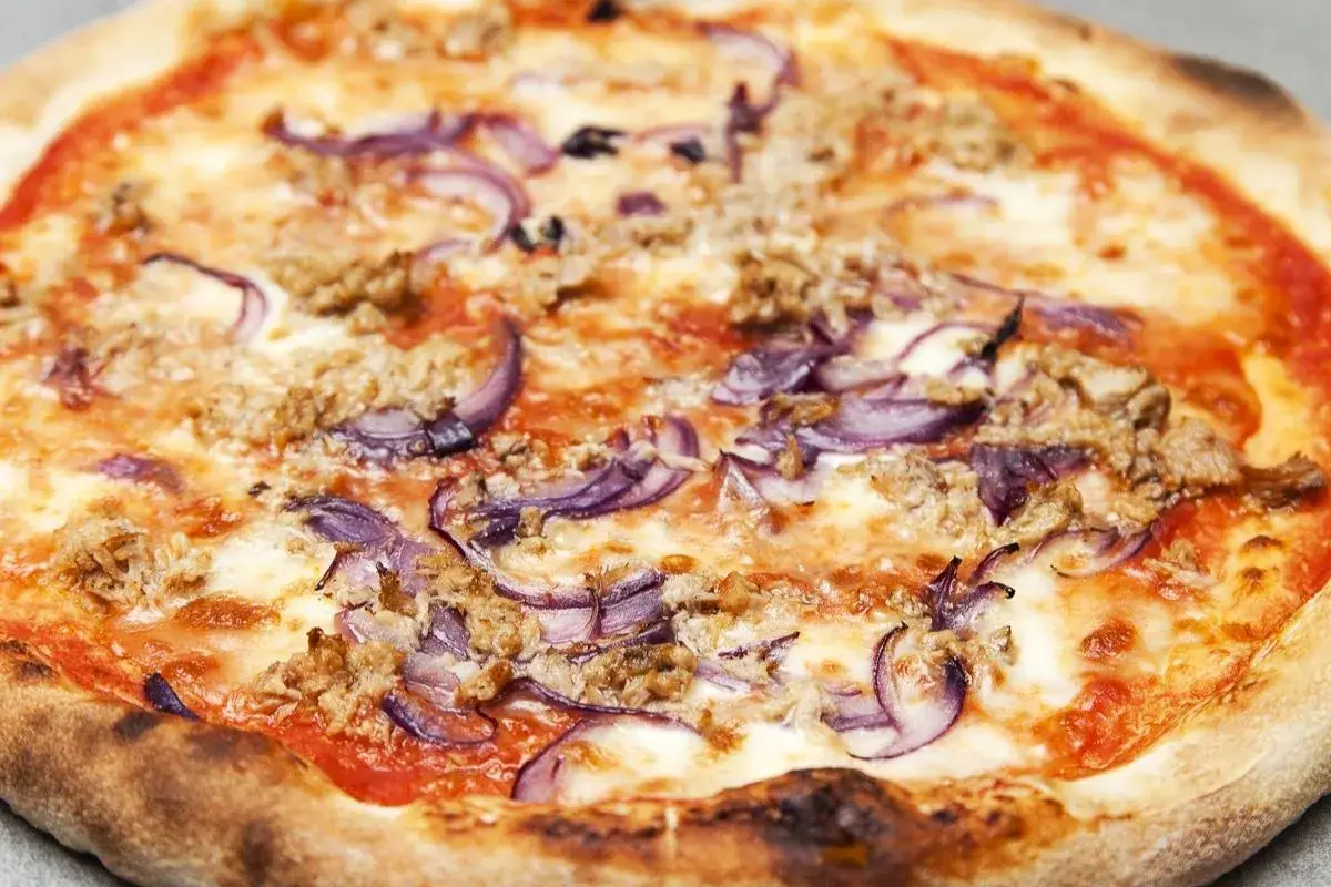 Pizza tonno e cipolla con crosta dorata e ingredienti succulenti.