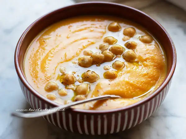 Un cremoso passato di verdure arancione, guarnito con ceci e un filo d'olio. Perfetto per una cena confortante.