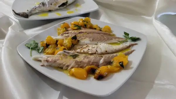 Orata in friggitrice ad aria, servita con pomodorini gialli e prezzemolo. Un piatto leggero e gustoso.