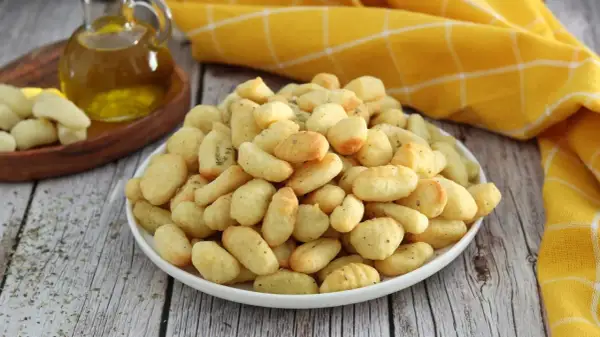 Gnocchi dorati e croccanti, preparati in friggitrice ad aria, conditi con erbe aromatiche.