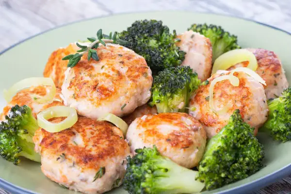 Deliziose polpette di merluzzo dorate, servite con cimette di broccoli croccanti e anelli di cipolla. Un piatto sano e gustoso.