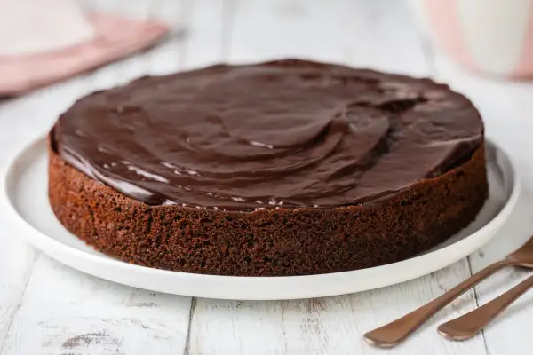 Una deliziosa torta al cioccolato morbida, ricoperta da una glassa lucida e invitante, pronta per essere gustata.