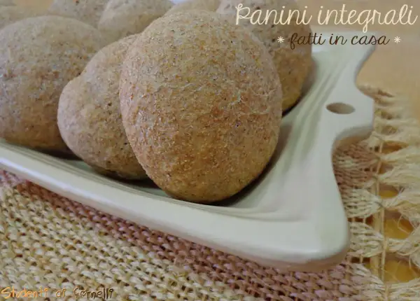 Panini integrali fatti in casa, morbidi e fragranti, serviti su un piatto bianco.