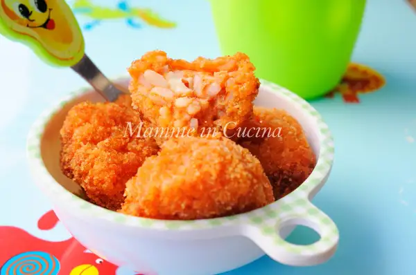 Polpette di riso dorate e croccanti, con un cuore filante di formaggio, servite in una ciotola a quadretti.