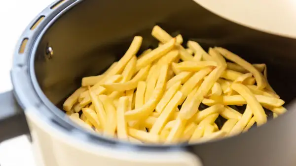 Patate dorate e croccanti pronte per essere gustate, appena uscite dalla friggitrice ad aria.