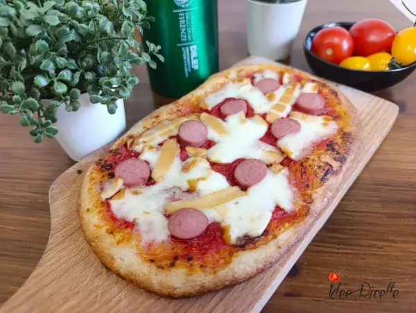 Deliziose pizzette fatte in casa con wurstel e formaggio filante, pronte per essere gustate.