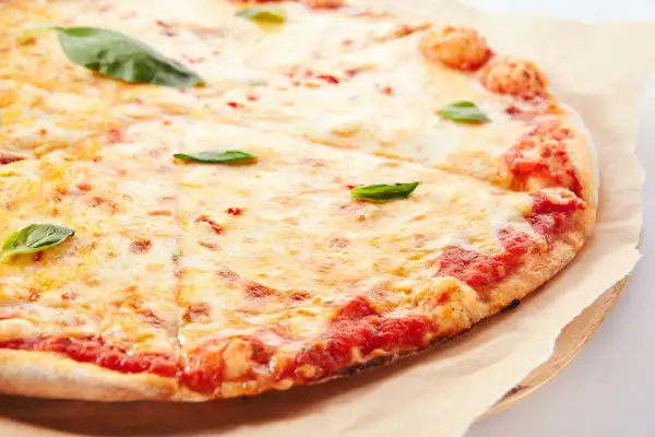 Pizza margherita con lievito istantaneo, croccante e dorata, con abbondante mozzarella filante e basilico fresco.