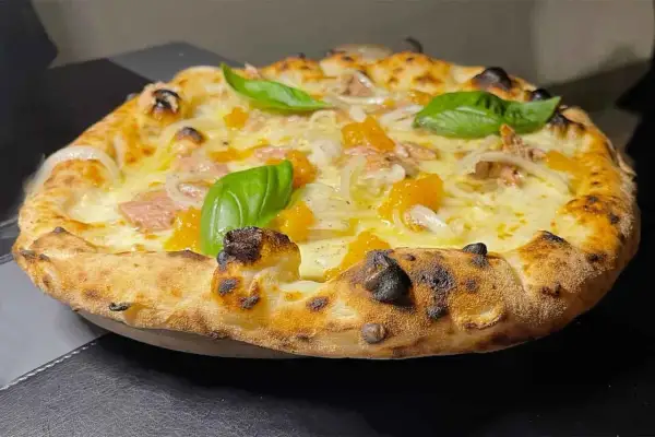 Pizza tonno e cipolla con mozzarella filante, pomodorini e basilico fresco. Croccante e saporita, un classico intramontabile.