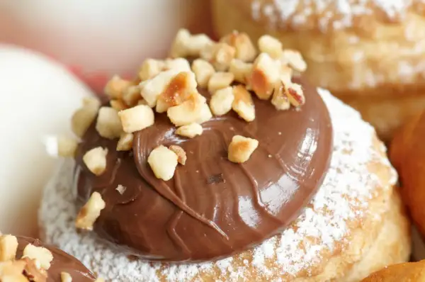Dolcetti di pasta sfoglia rettangolare, ricoperti di zucchero a velo e generosa crema alla Nutella, guarniti con granella di nocciole croccanti.