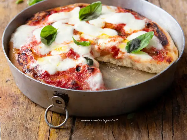 Pizza margherita appena sfornata in friggitrice ad aria, con mozzarella filante e basilico fresco.