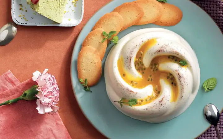 Deliziosa crema al latte con frutto della passione e biscotti croccanti, guarnita con menta fresca.